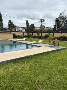 a swimming pool with a table and chairs in the grass at Campbell Residence Bouaké in Bouaké