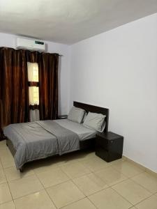 a bedroom with a bed and a window with curtains at Campbell Residence Bouaké in Bouaké +5 photos