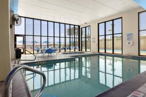 a swimming pool with tables and chairs and windows at Updated 3BR w/ Gulf Views: Suntide III - Unit 801 in South Padre Island