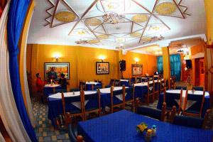 a dining room with blue tables and chairs at Hôtel Auberge du Littoral in Aourir