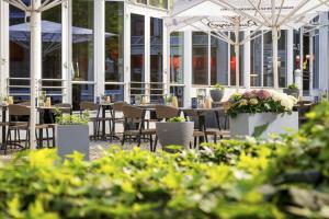 a restaurant with tables and chairs and plants at Best Western Plus Hotel Dresden City in Dresden