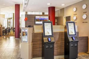 a lobby with two atm machines in front of a restaurant at Best Western Plus Hotel Dresden City in Dresden