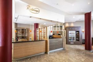 a restaurant with a large counter with a showcase at Best Western Plus Hotel Dresden City in Dresden +83 photos