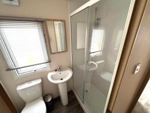 a bathroom with a shower and a toilet and a sink at Beach Resort Kamperland - 1152 in Kamperland +24 photos