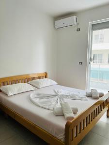 a large bed in a room with a window at Apartament bisaku in Shëngjin