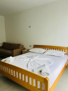 a bedroom with a bed with white sheets and pillows at Apartament bisaku in Shëngjin