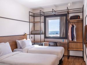 a hotel room with two beds and a window at ibis Jaú in Jaú