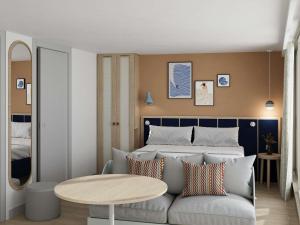 a bedroom with a bed and a couch and a table at Domaine des Grands Sables, Île Groix - Handwritten Collection in Groix