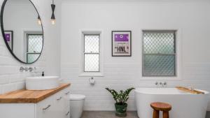 a bathroom with a tub and a sink and a mirror at Bruns Beach Shack in Brunswick Heads