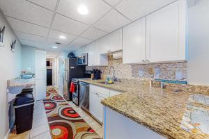 a kitchen with white cabinets and marble counter tops at White Marlin 303B in Ocean City