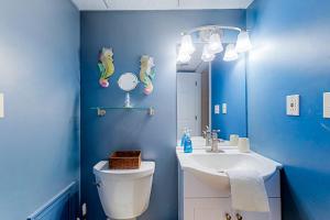 a blue bathroom with a toilet and a sink at White Marlin 303B in Ocean City +22 photos