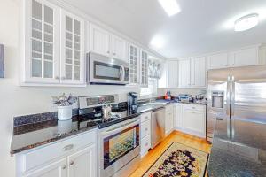 a kitchen with white cabinets and stainless steel appliances at The Sea Captain's Sanctuary in Ocean City +17 photos