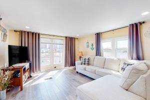 a living room with a white couch and a tv at Montego Bay - Atlantic 13300 in Ocean City