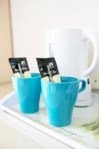 two blue cups filled with toothbrushes on a tray at The Haldon Guest House in Paignton