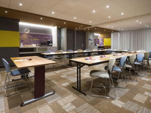 a group of tables and chairs in a room at ibis Deauville Centre in Deauville
