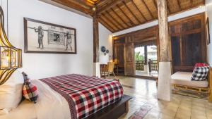 a bedroom with a bed and a chair in a room at The Joglo at Umah Sunset in Ubud +37 photos