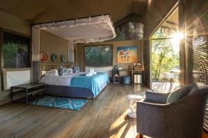 a bedroom with a large bed and a patio at Chundu Island in Victoria Falls +74 photos