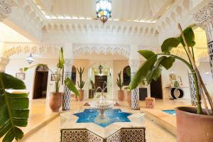 a large room with a fountain and plants in it at Palais Zoya in Marrakesh