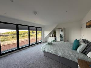 a bedroom with a large bed and large windows at Fort View- Totland in Totland