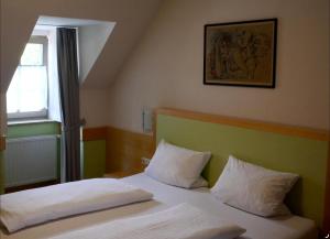 a bedroom with two beds and a painting on the wall at Bocksbeutelherberge in Sommerach
