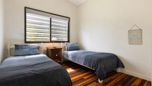 two beds in a small room with a window at L'Aqua by Lifestyle. in New Brighton