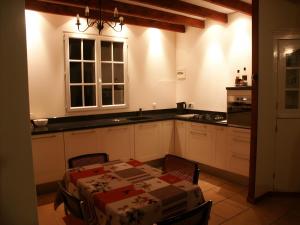 a kitchen with a table and a sink and a table and chairs at Petit Crecy 