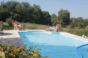 a group of people sitting around a swimming pool at Petit Crecy 