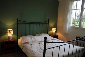 a bedroom with a bed with two lamps on tables at Petit Crecy  +21 photos