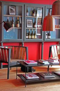 een kamer met een tafel en stoelen en planken met flessen bij Hôtel Courtille de Solutré in Solutré-Pouilly