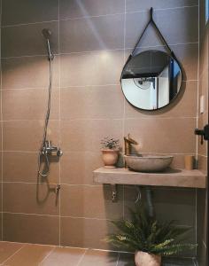 a bathroom with a shower and a mirror on the wall at Monoi Home in Vinh
