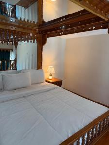a bedroom with a large bed with a wooden canopy at Kuwait Palace Hotel in Kuwait +41 photos