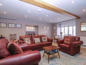 a living room with leather couches and a table at 19 Lion Street in Hereford