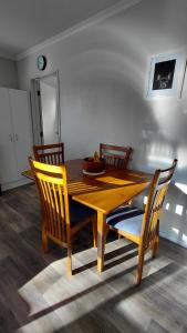 a wooden table and chairs with a bowl of fruit on it at Private Flat in Bridge Hill in Alexandra