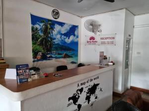 a reception desk with a map of the world on the wall at Lucky Buako Hotel Patong in Patong Beach