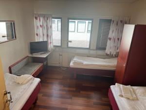 a room with two beds and a desk with a television at Carlssons matsalar in Gislaved