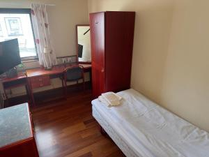 a bedroom with a bed and a cabinet and a desk at Carlssons matsalar in Gislaved