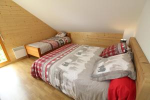 a bedroom with two twin beds in a attic at Chalet avec mezzanine 4 étoiles, Saint Mamet, jusqu'à 10 couchages, proche du lac de Gérardmer des commerces et des pistes de ski dans un quartier calme in Gérardmer