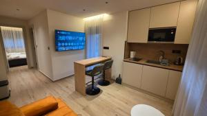 a room with a desk and a kitchen with a bed at Villa Jelena Rooms and Apartments in Kovačić