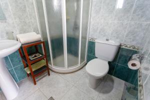 a bathroom with a shower and a toilet and a sink at Apartamento Playa de Lires in Cee +13 photos