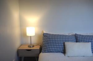 a bedroom with a bed with a lamp on a night stand at Private Flat in Bridge Hill in Alexandra