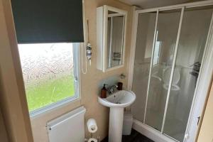 a small bathroom with a sink and a shower at 2 Bedroom Caravan - Sleeps 6 - Parking Seaside in Abergele +12 photos