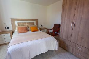 a bedroom with a bed and a cabinet and a chair at Apartamento Playa de Lires in Cee