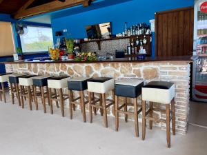 a row of stools at a bar at Boutique Hotel Ileas Village in Arkoudi