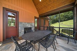a table and chairs on a porch with a fireplace at Mio Nido at Eagles Nest in Newland