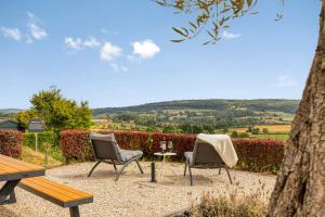 two chairs and a table and a bench in a garden at Hoeve de Eik in Epen