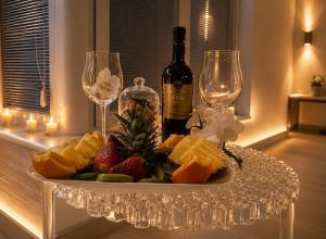 a plate of fruit with a bottle of wine and glasses at OLYMPUS PARK amnesia in Mesagne
