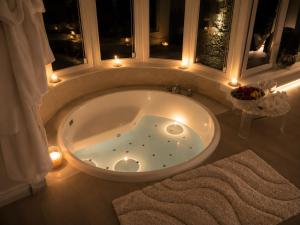a bath tub in a bathroom with lights in it at OLYMPUS PARK amnesia in Mesagne