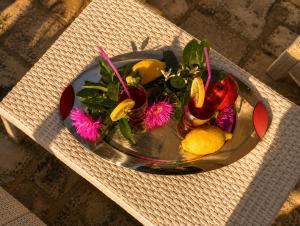 a plate of fruit and flowers on a table at OLYMPUS PARK amnesia in Mesagne +18 photos
