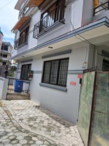 a white building with a gate in front of it at Aangan Homestay in Pātan
