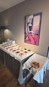 a table with food on it with a painting on the wall at Pension Hauenstein in Lagundo